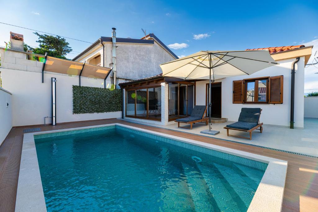 a swimming pool in the backyard of a house at Holiday house "Maria" in Privlaka