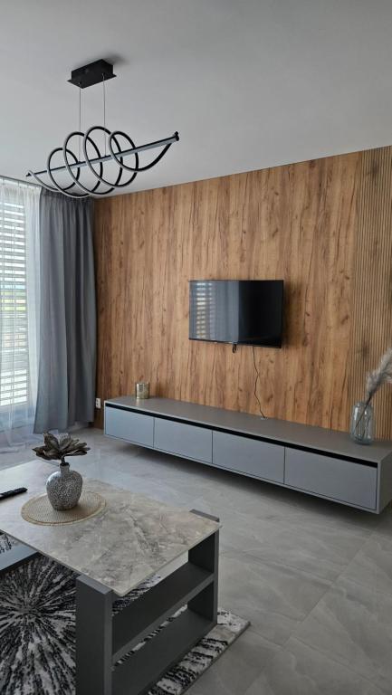 a living room with a television on a wall at Apartman Bartimej 3A in Bobrów