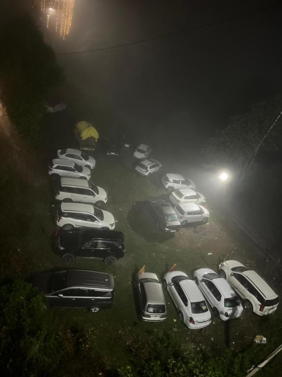 a bunch of cars parked in a parking lot at night at Hotel CHINTPURNI JMC in Bharwain
