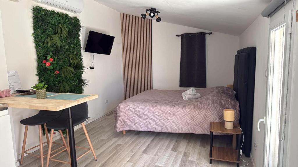a bedroom with a bed and a desk and a table at Studio nature in Saran