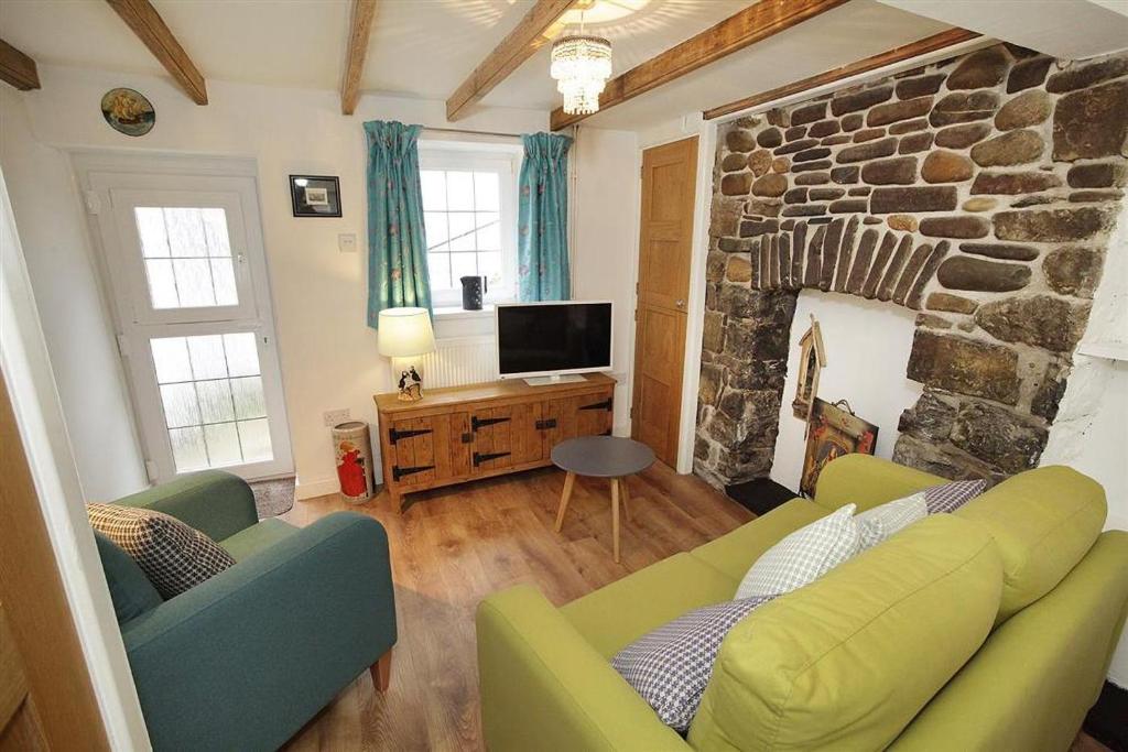 a living room with two couches and a stone fireplace at 1 Bed in Mumbles oc-hh1210 in The Mumbles