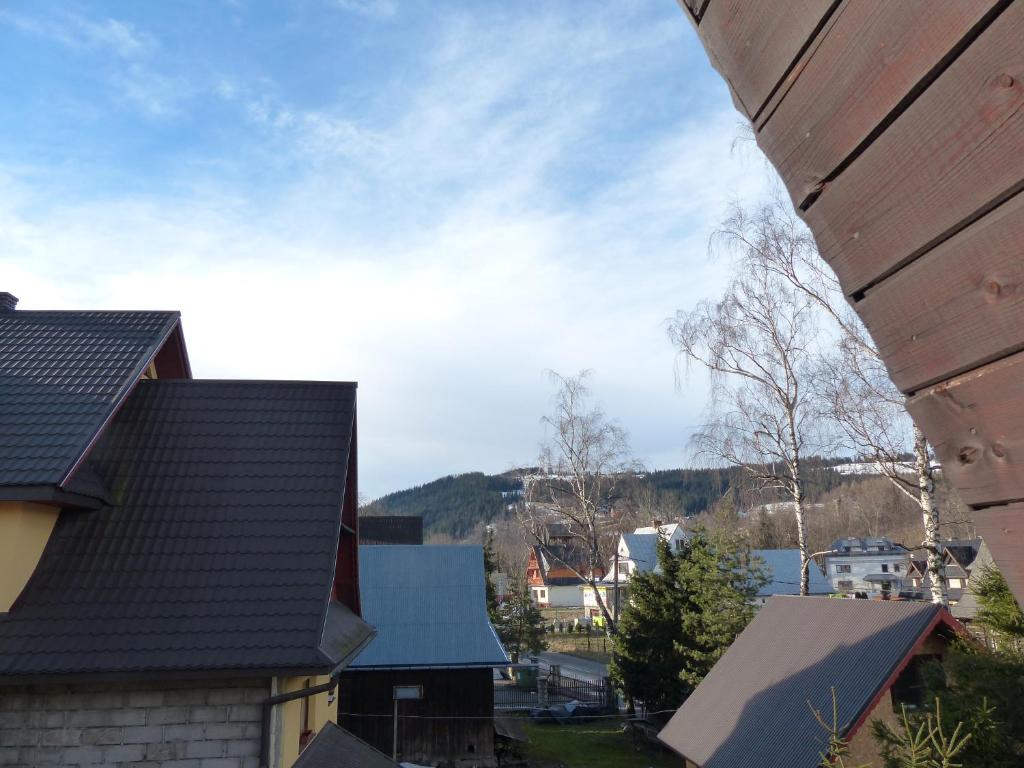 a view of roofs of houses with mountains in the background at Pokoje u ZośkiP in Zakopane