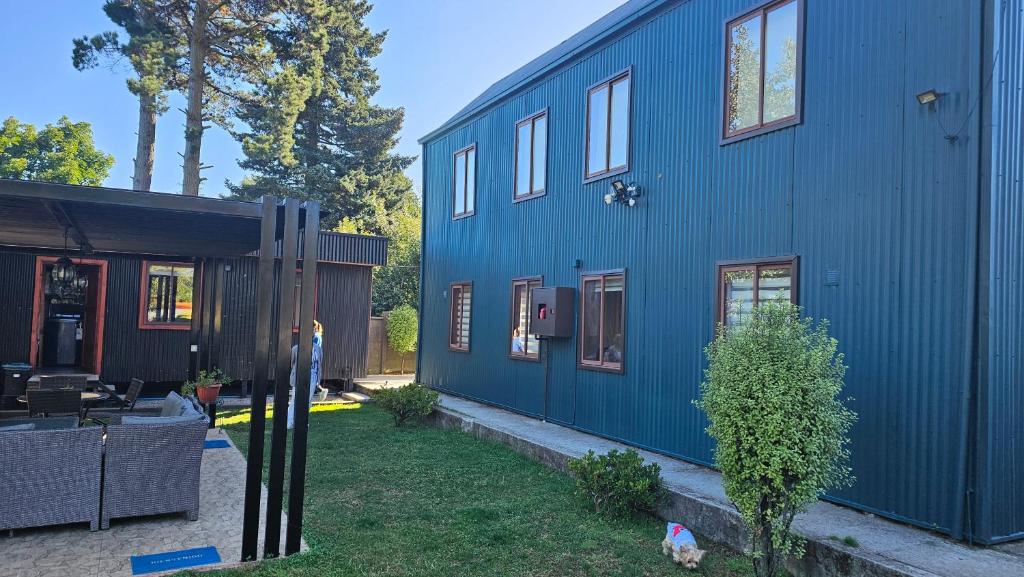 a blue house with a yard next to a building at Cabañas Rosner in Valdivia