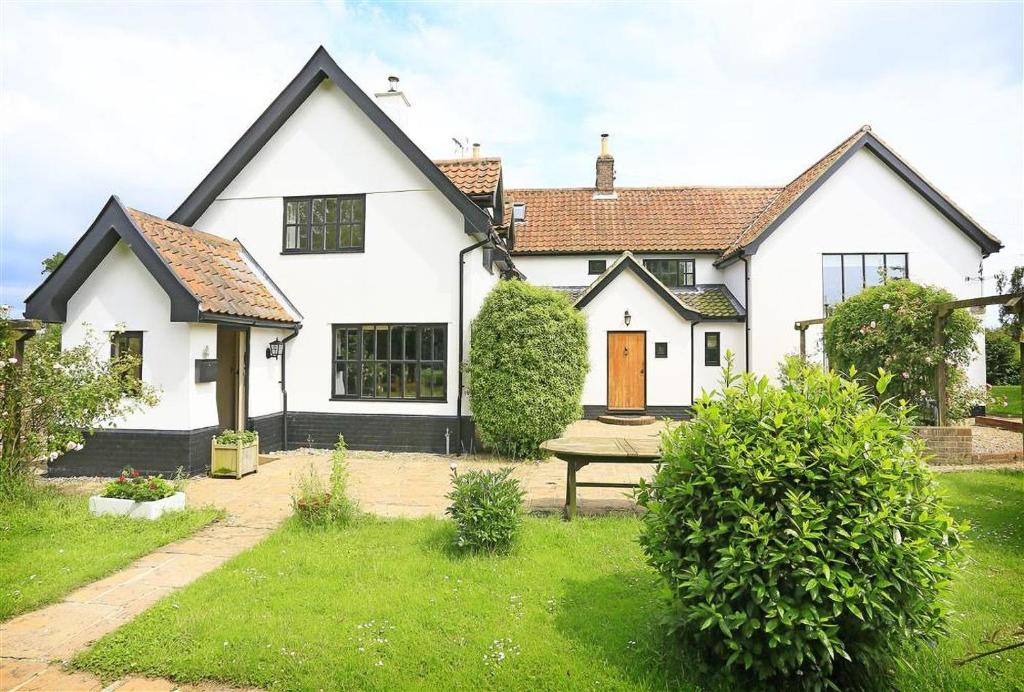 a white house with a picnic table in the yard at 5 Bed in Beccles oc-ksf in Wangford
