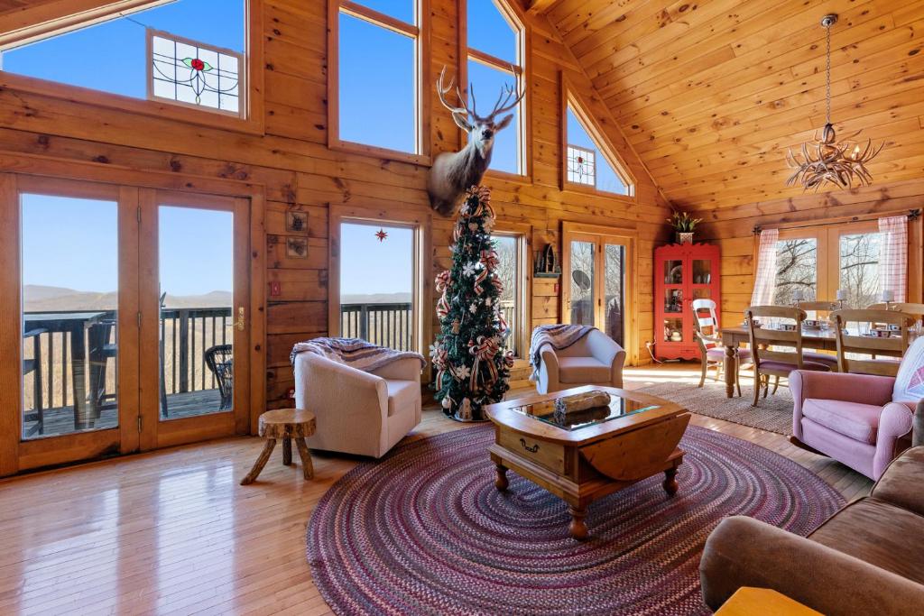a living room with a christmas tree in a cabin at Cupids Retreat in Boone