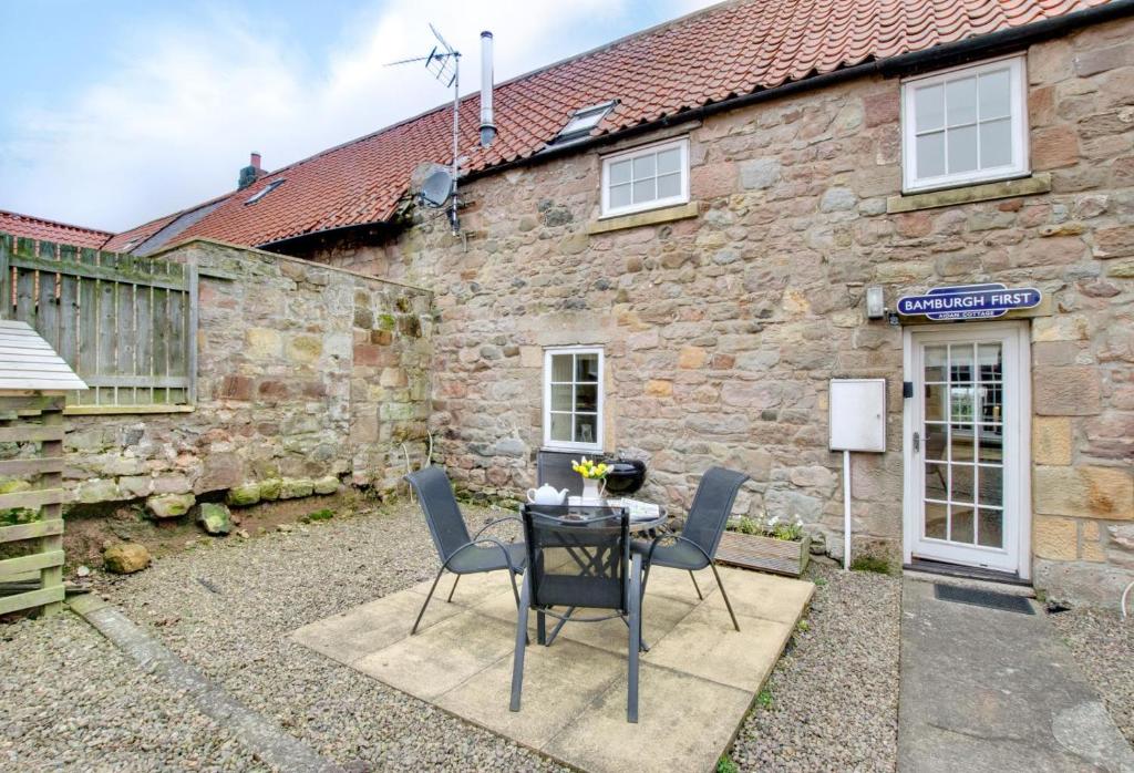 a table and chairs in front of a stone building at 2 Bed in Belford oc-gd1023 in Warenford