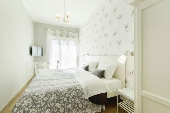um quarto branco com uma cama e uma janela em B&B Margarita em Nápoles