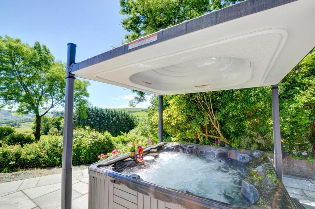 an outdoor hot tub under a white umbrella at 3 Bed in Llanidloes oc-waa246 in Llangurig