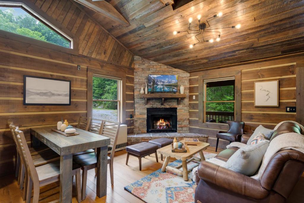 a living room with wooden walls and a fireplace at Eagle Ridge Creek in Banner Elk