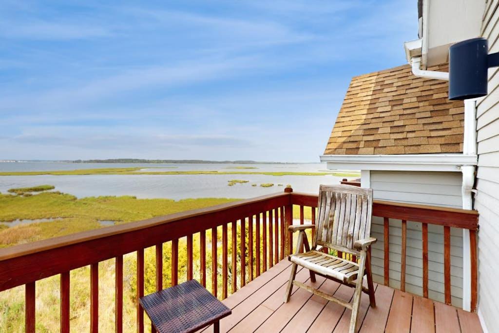 a chair sitting on a deck with a view of the water at Seatowne - 36912 Bayside in Fenwick Island