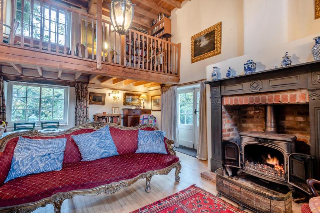 a living room with a red couch and a fireplace at 4 Bed in Reepham oc-497 in Reepham