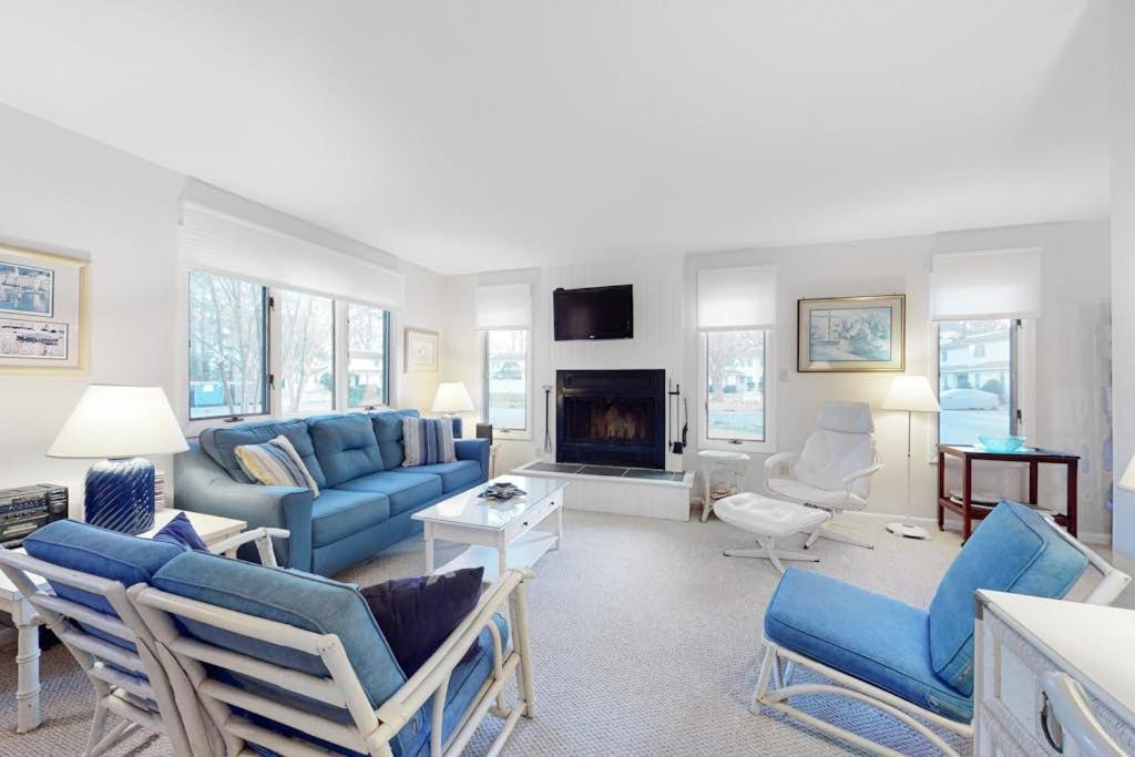 a living room with blue furniture and a fireplace at Bethany Pines -- 412 Bethany Drive in Bethany Beach