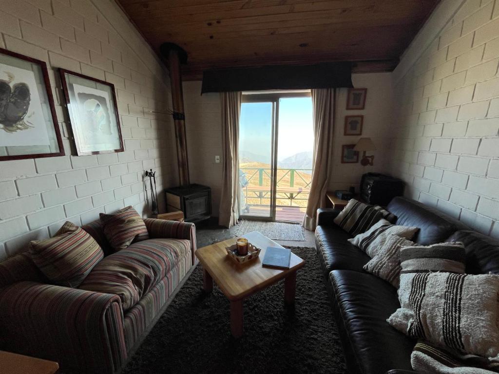 a living room with a couch and a table at Refugio de Montaña, excepcional in El Colorado