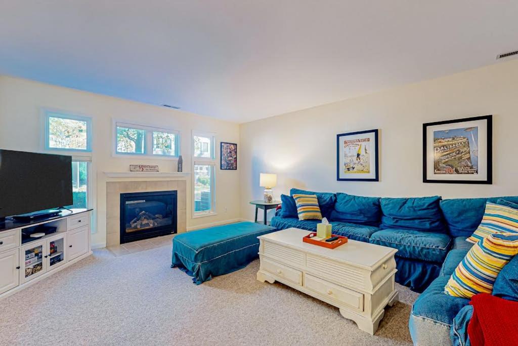a living room with a blue couch and a tv at Sea Colony --- 56200 Pine Cone Ln in Bethany Beach