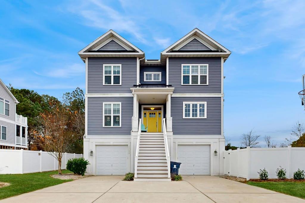 a gray house with a yellow door and a white fence at 39609 Waterworks Ct in Bethany Beach