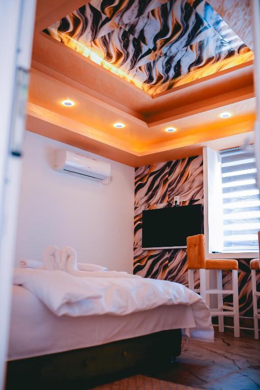 a bedroom with a bed and a tv on a wall at Lux apartmani Savić in Aleksinac