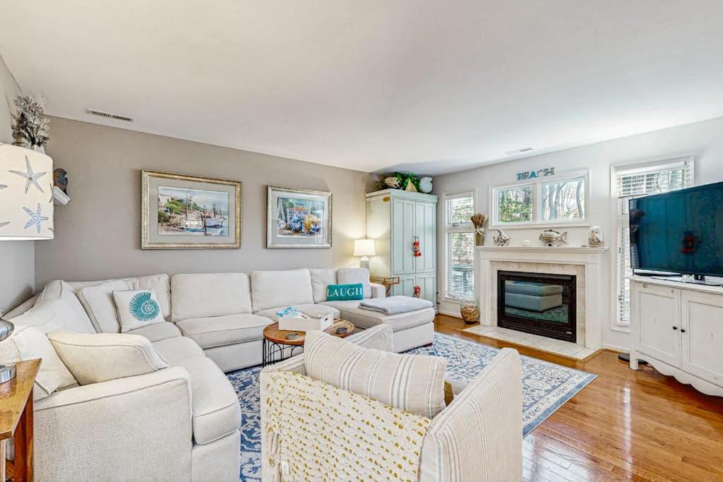 a living room with white furniture and a fireplace at Sea Colony - 55073 Pine Shore in Bethany Beach