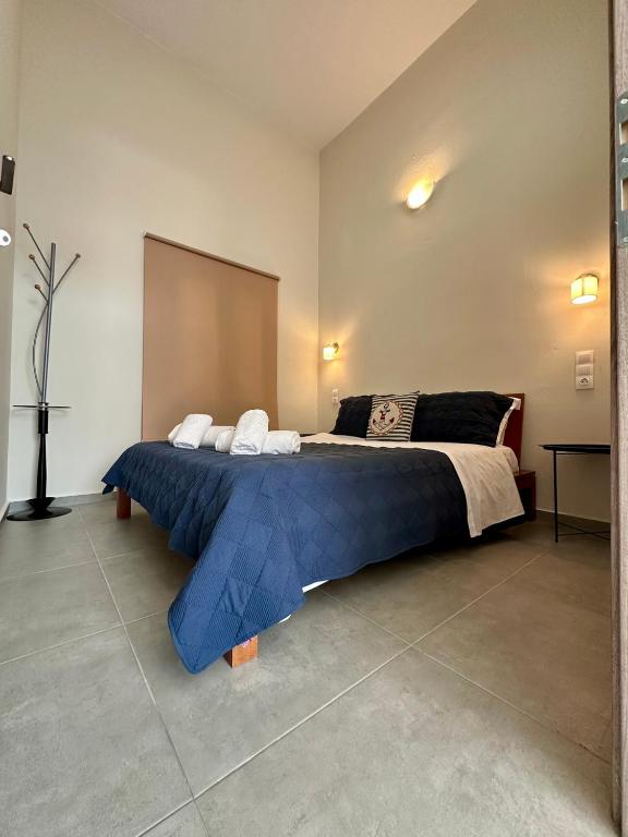 ein großes Schlafzimmer mit einem großen Bett mit blauer Bettwäsche in der Unterkunft Rodia 2 in Pteleos