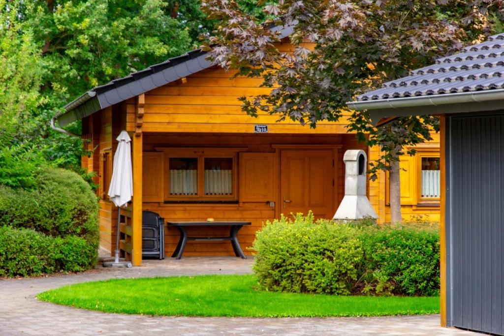 a wooden cabin with a picnic table in front of it at Waldsiedlung - Haus 10 in Großkoschen