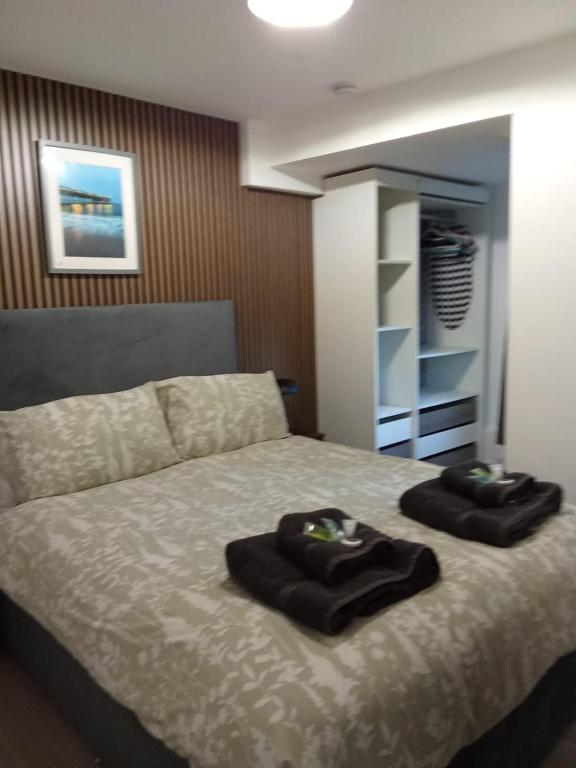 a bedroom with a bed with two towels on it at Swannery Vista 1 Bedroom Apartment in Weymouth