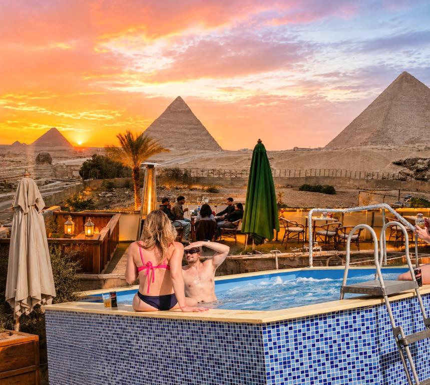 a couple in a hot tub at the pyramids at Pyramids Height Hotel & Pyramids Master Scene Rooftop in Cairo
