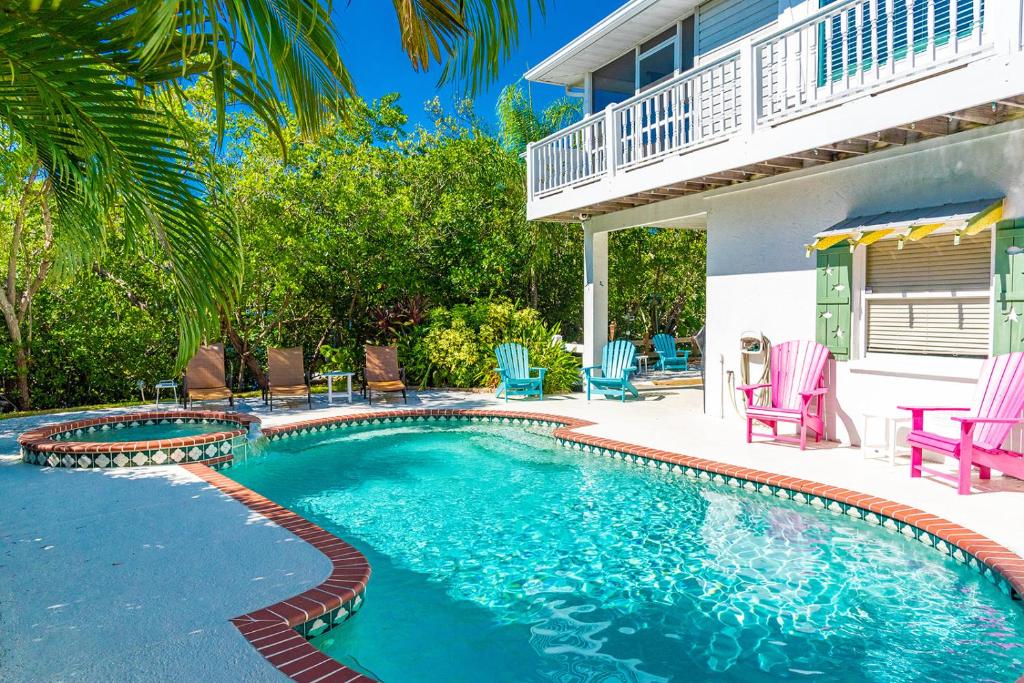 a swimming pool in front of a house at White Shell in Anna Maria