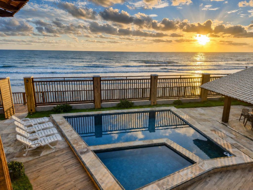 a swimming pool with a view of the ocean at Luxury Oceanfront House - Beachfront - Pool in Aquiraz