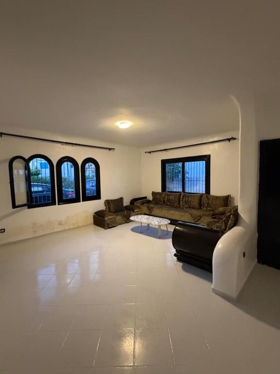a large living room with couches and windows at Soumaya plage appartement in Fnidek