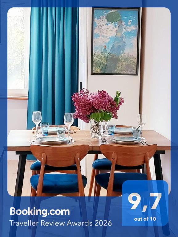 a table with two chairs and a vase of flowers at Rumia Cichy Zaułek 2 in Rumia