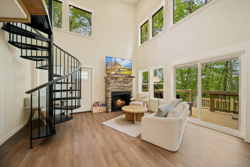 a living room with a staircase and a fireplace at Appalachian Cottage in Blowing Rock