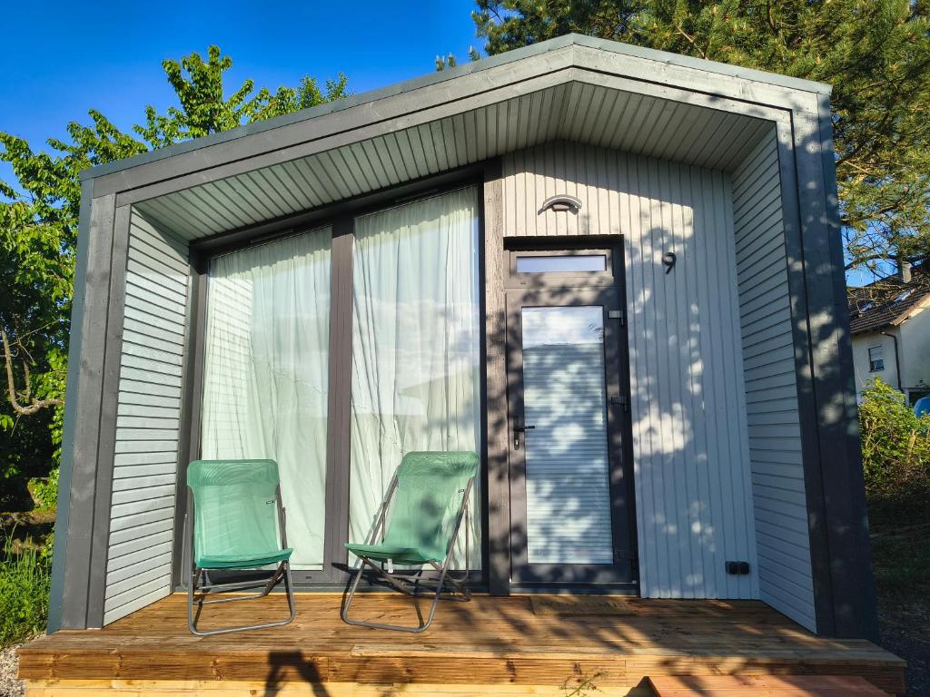 two green chairs sitting on a wooden deck in a shed at Tiny House Am Guckenberg in Diez in Diez