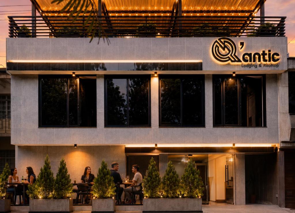 a group of people sitting at tables in front of a building at Qantic Lodging & Rooftop in Medellín