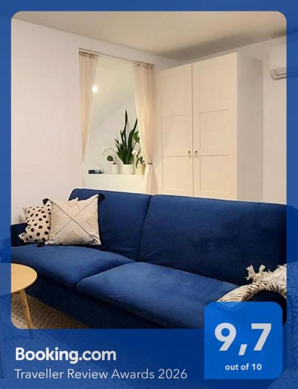 a blue couch in a living room with a table at Rumia Cichy Zaułek 5 in Rumia