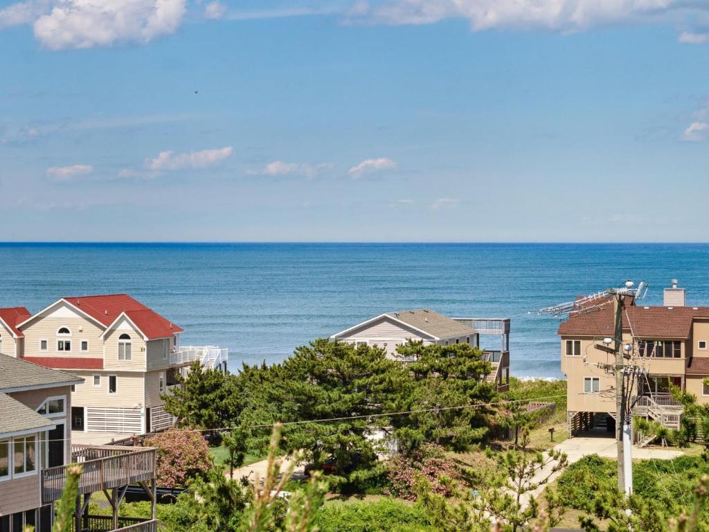 a row of houses with the ocean in the background at 2030 - Horizon`s Summit in Duck