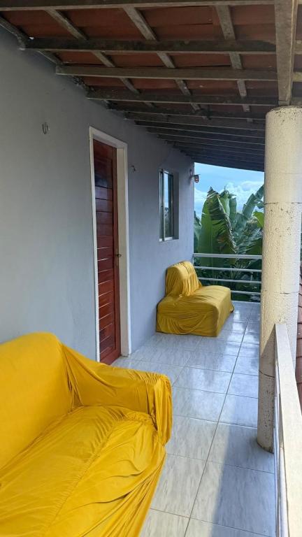 a room with two yellow beds on a balcony at Suite em Mulungu in Mulungu