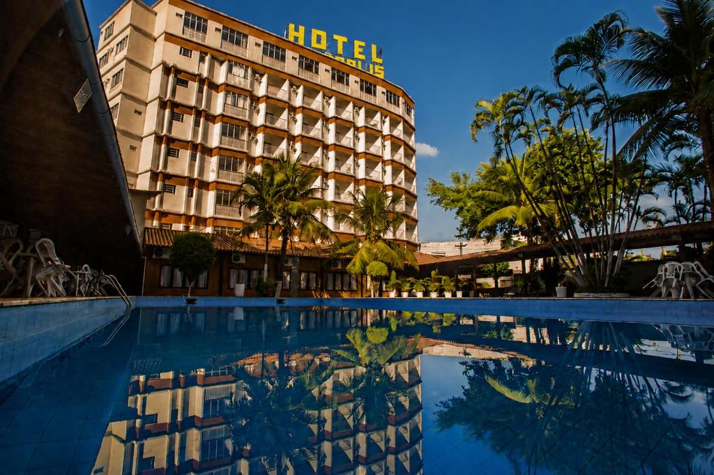 a hotel with a swimming pool in front of a building at Acrópolis Marina Hotel in Angra dos Reis