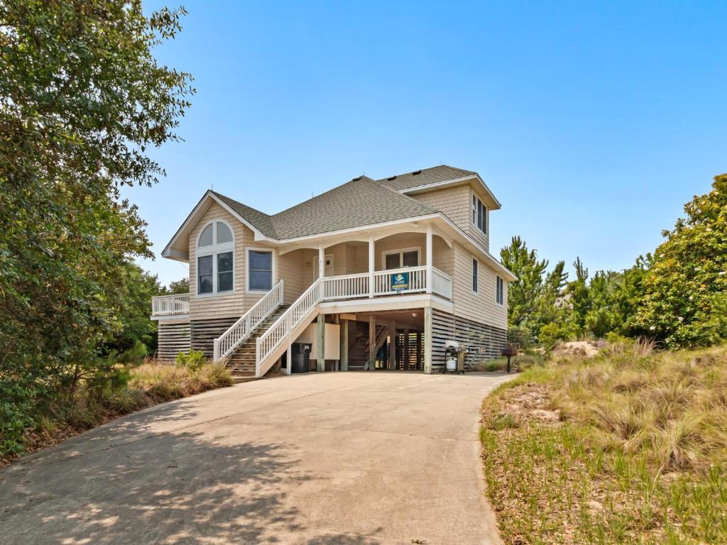 a house on a hill with a driveway at 4160 - Shipley in Kitty Hawk