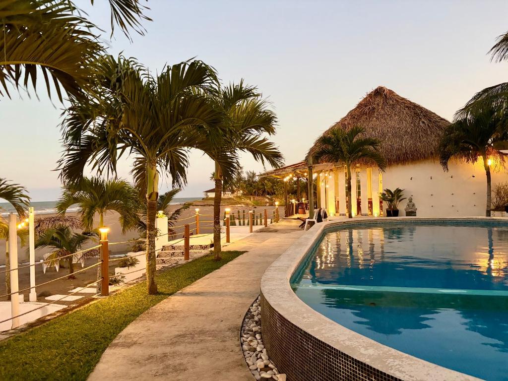 a resort with a swimming pool and palm trees at Hotel Lunazul In Costa Esmeralda in La Vigueta