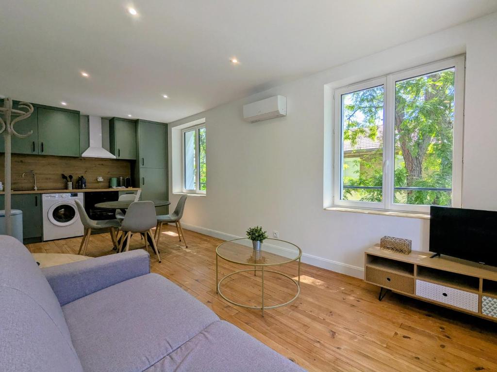 a living room with a couch and a table at Air-conditioned apartment - two bedrooms in Vichy