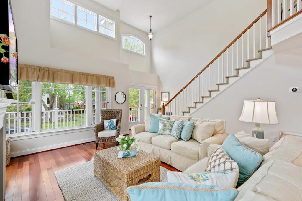 a living room with white furniture and a staircase at Bethany West -- 719 Fenwood in Bethany Beach