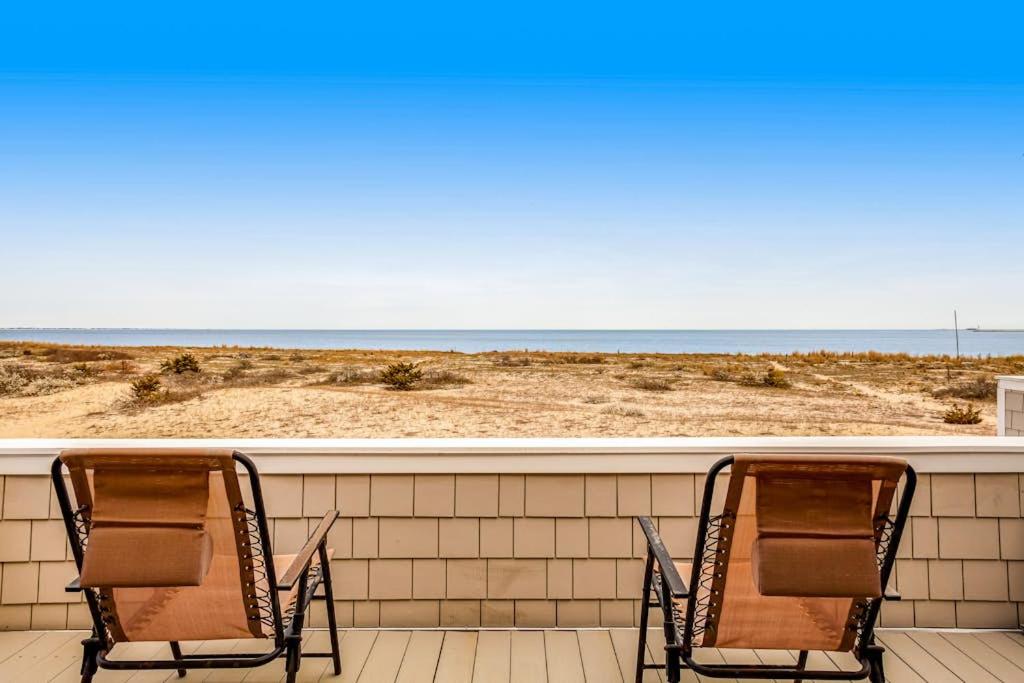 two chairs sitting on a balcony looking out at the beach at Lewes --- 6 Pilot Point in Lewes