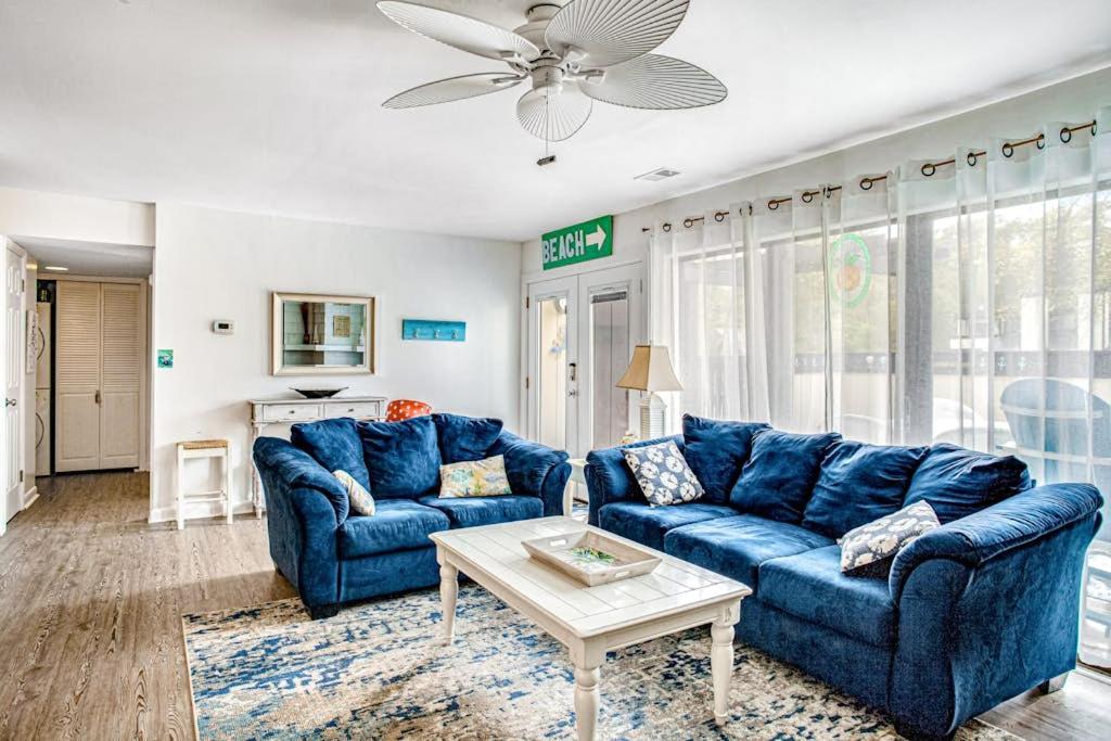 a living room with blue couches and a table at Sea Colony - 903 Singles Ct in Bethany Beach