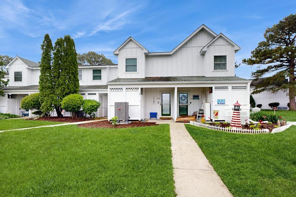 a white house with a lawn and a sidewalk at Mallard Lakes - 142 Cardinal in Selbyville
