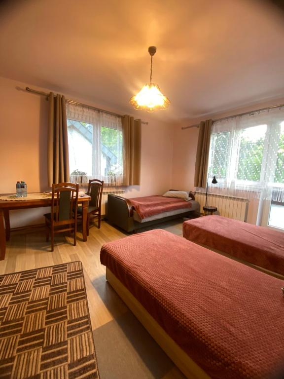 a hotel room with two beds and a table at Pokoje Gościnne Pod Lasem" in Balice