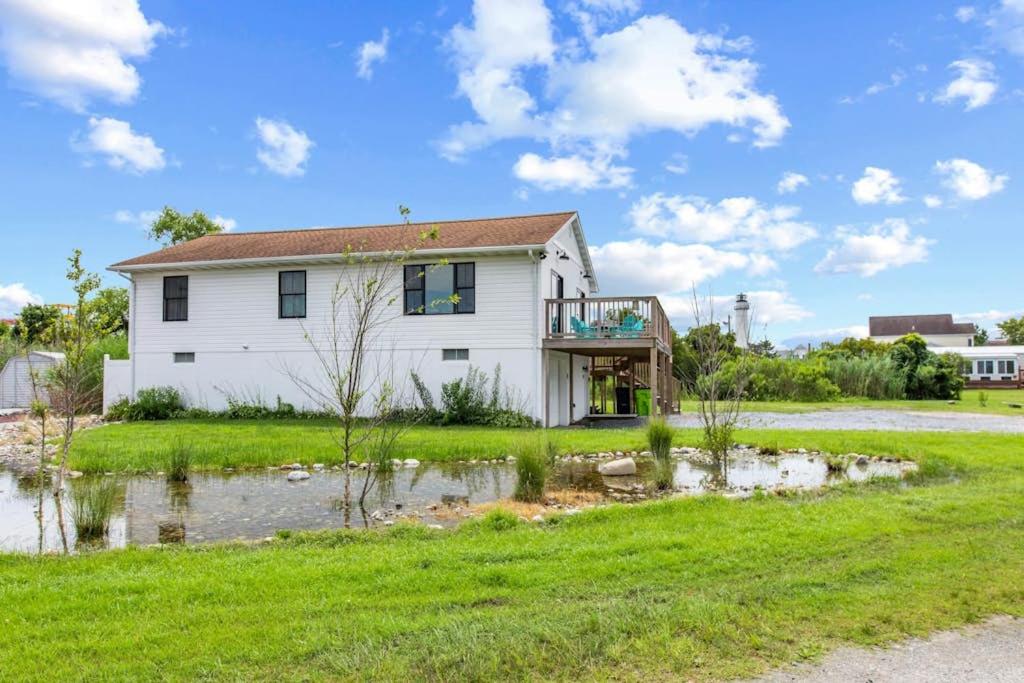 a white house with a balcony in a yard at Fenwick Island -- 28 High Tide in Fenwick Island