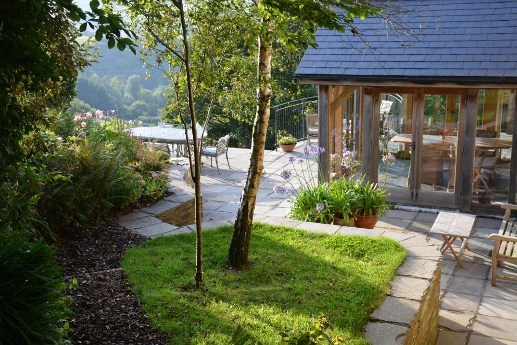 a garden with a patio and a table and chairs at Kerswell Farmhouse in Totnes