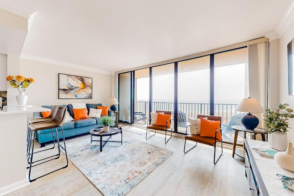 a living room with orange and blue furniture and large windows at Sea Colony - 708 Brandywine House in Bethany Beach