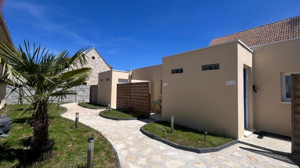 a row of houses with a palm tree next to them at Comme à la maison in Villiers-en-Bière