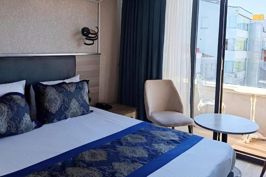 a hotel room with a bed and a chair and a window at Restwon Suite Hotel in Istanbul