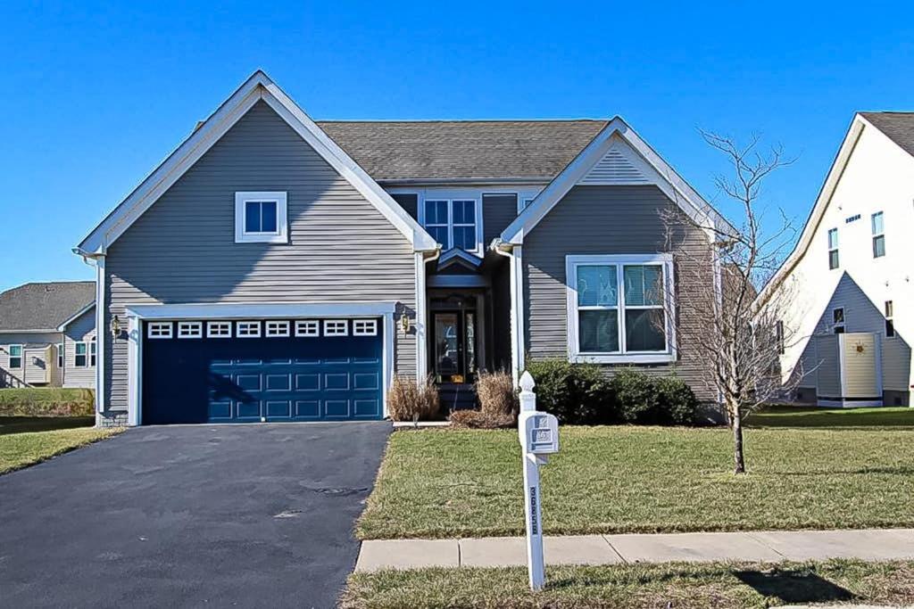 a house with a blue garage door and a driveway at Swann Cove - 36858 Herring in Selbyville